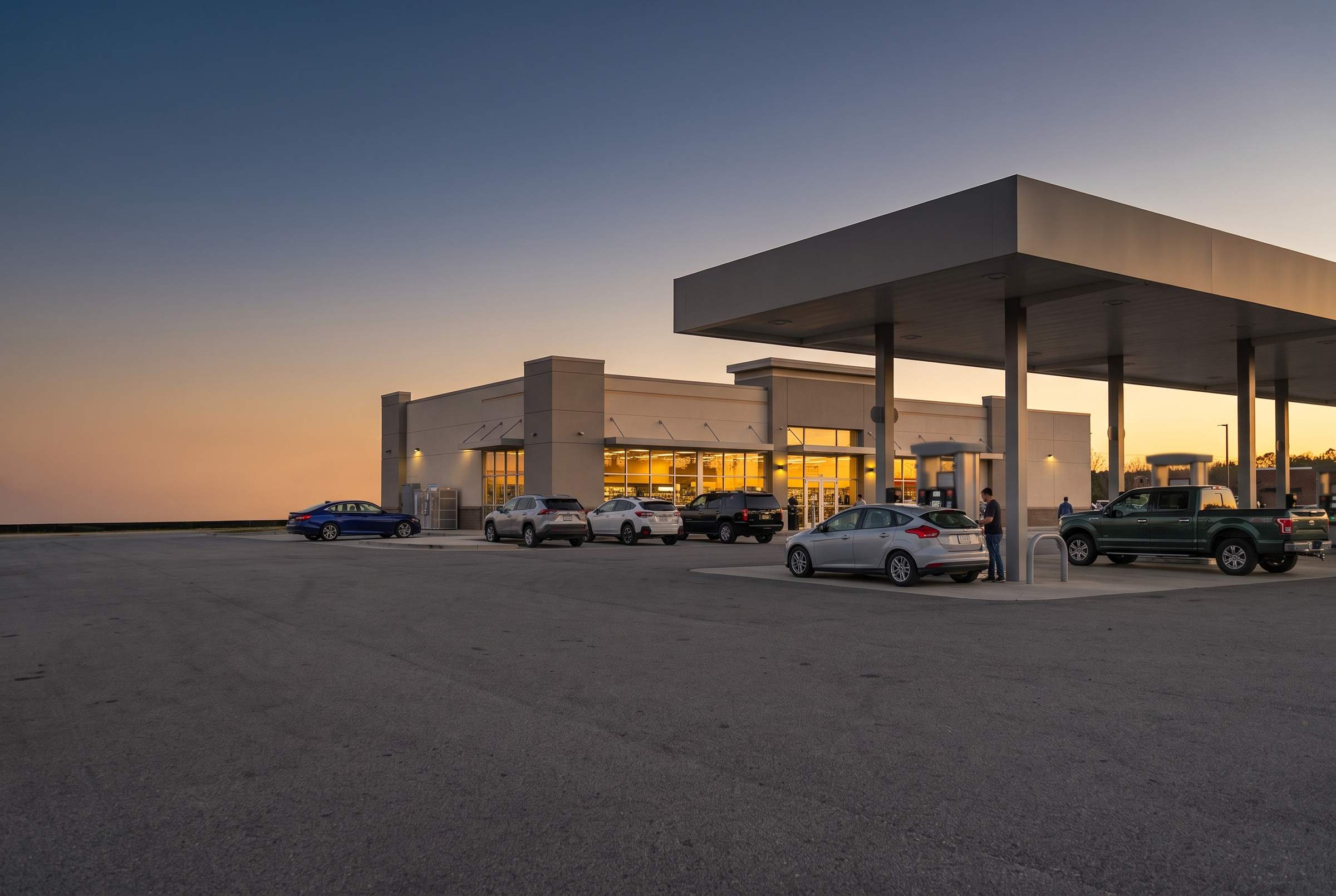 A convenience store and forecourt at golden hour