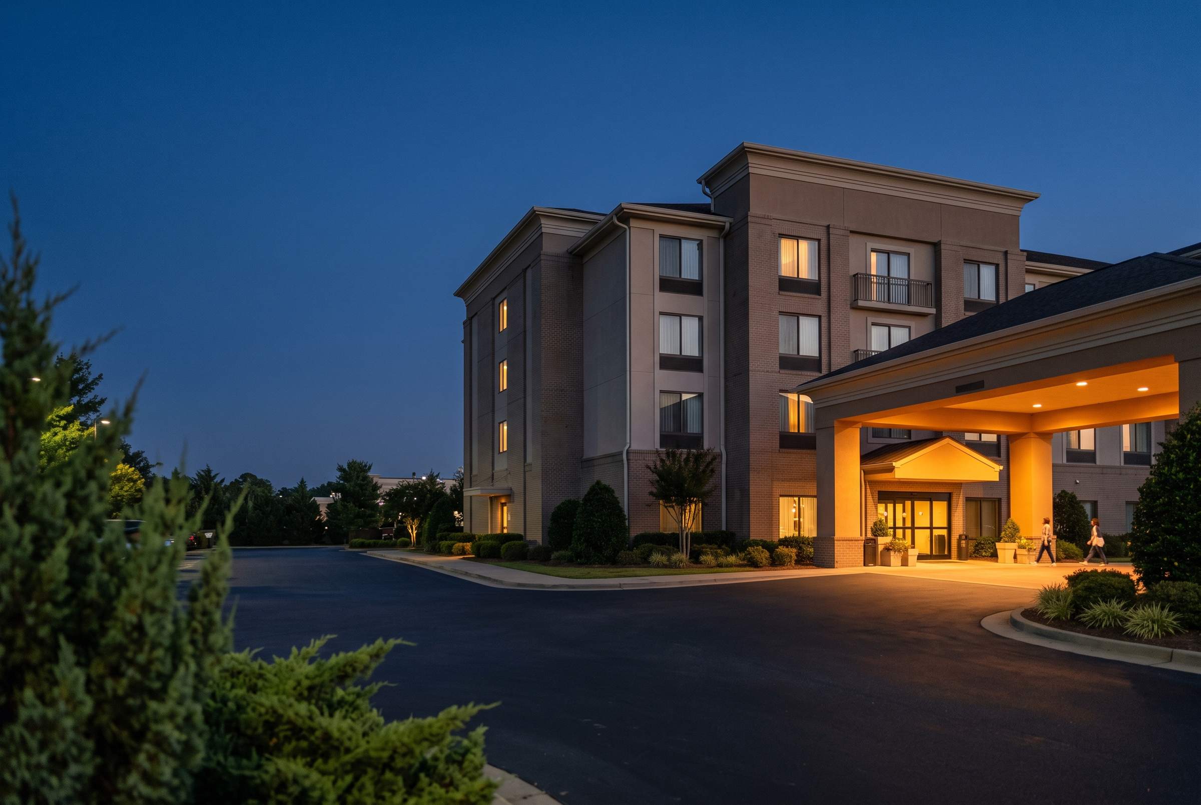 A mid-scale hotel exterior at blue hour