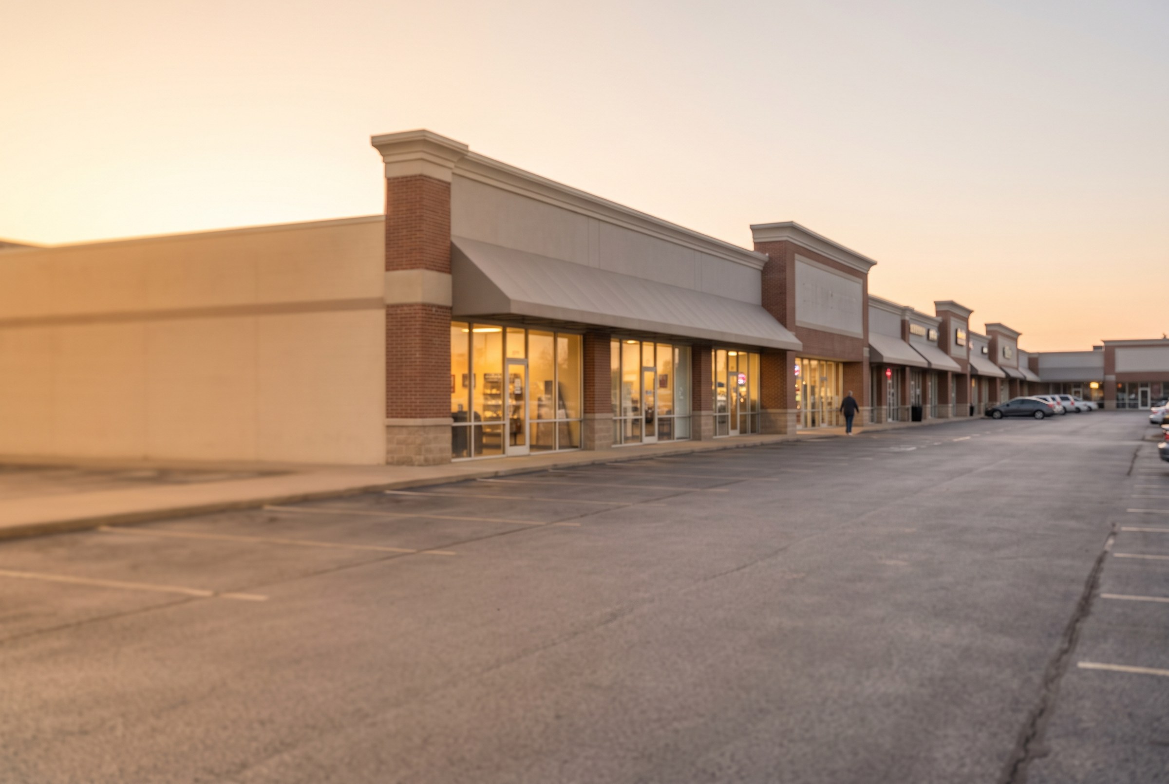 A neighbourhood strip shopping centre at golden hour